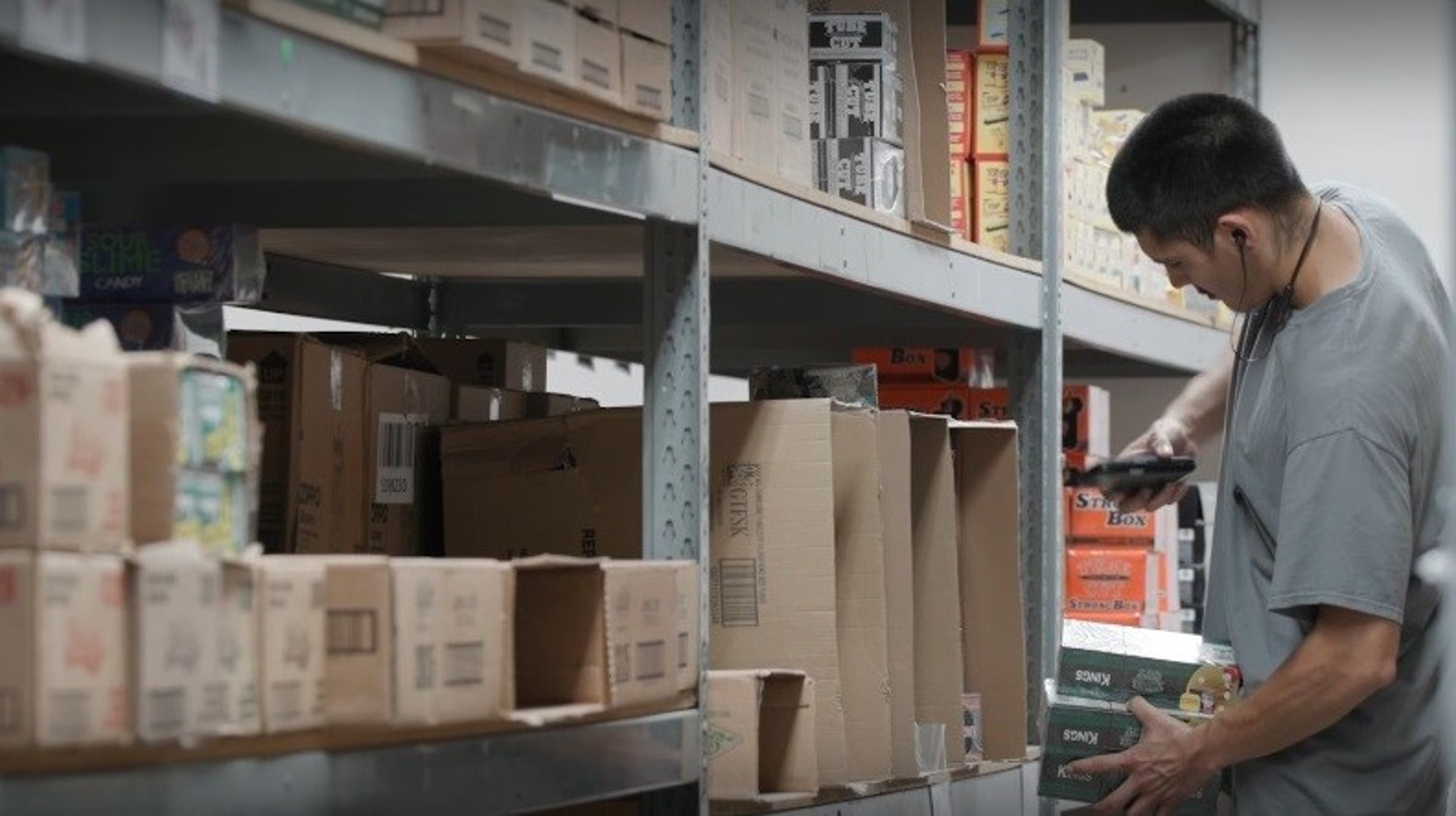 Blue Sky Distribution warehouse worker using a mobile warehouse management system (WMS software) with barcode scanning to scan item on warehouse shelf