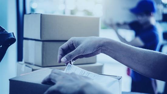 Beginner Ecommerce Shipper Placing a Shipping Label on a Parcel